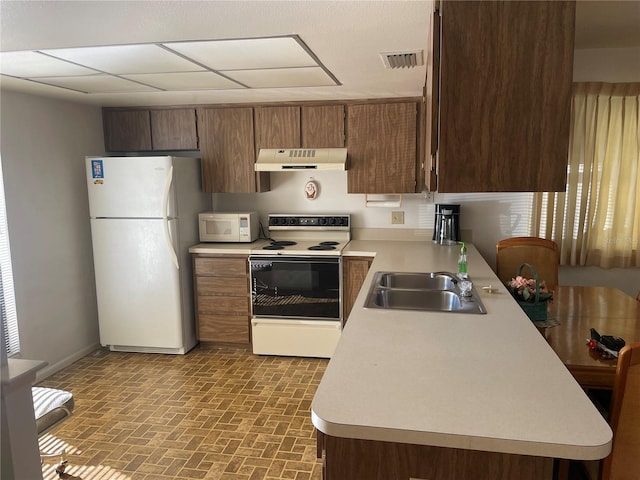 kitchen with sink, a drop ceiling, and white appliances