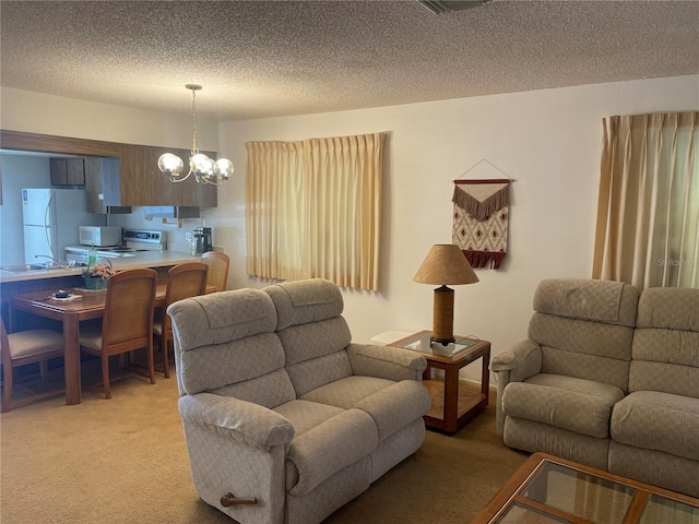 living room featuring carpet flooring, a textured ceiling, and an inviting chandelier