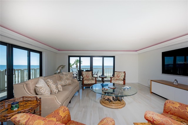 living room featuring a water view, light hardwood / wood-style flooring, plenty of natural light, and ornamental molding