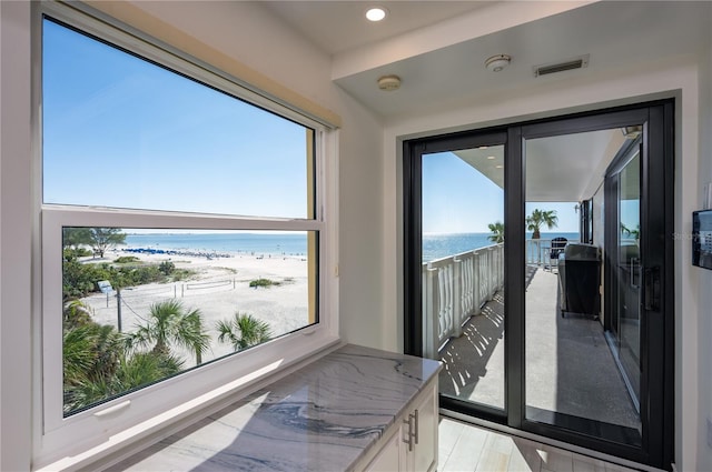 interior space featuring plenty of natural light, a water view, and hardwood / wood-style flooring