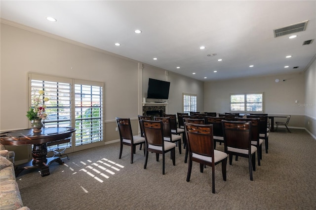 carpeted dining space featuring crown molding