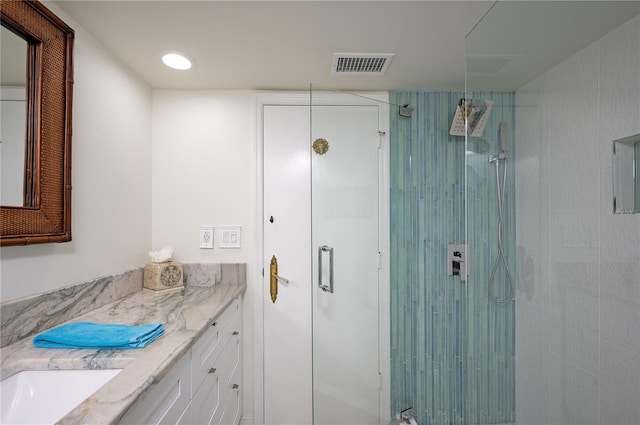 bathroom with vanity and a shower with shower door