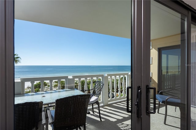 balcony featuring a water view and a view of the beach