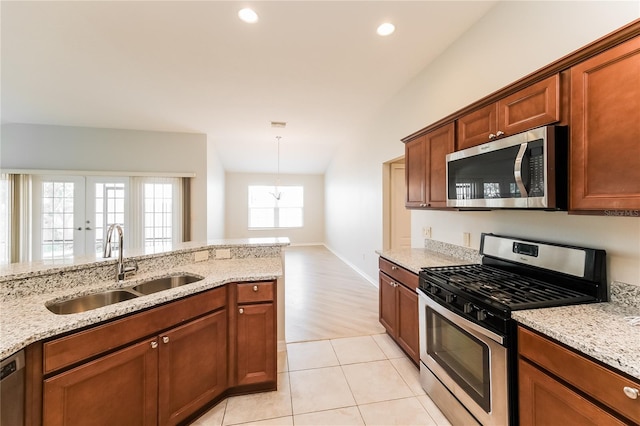 kitchen with light stone countertops, sink, french doors, appliances with stainless steel finishes, and light wood-type flooring