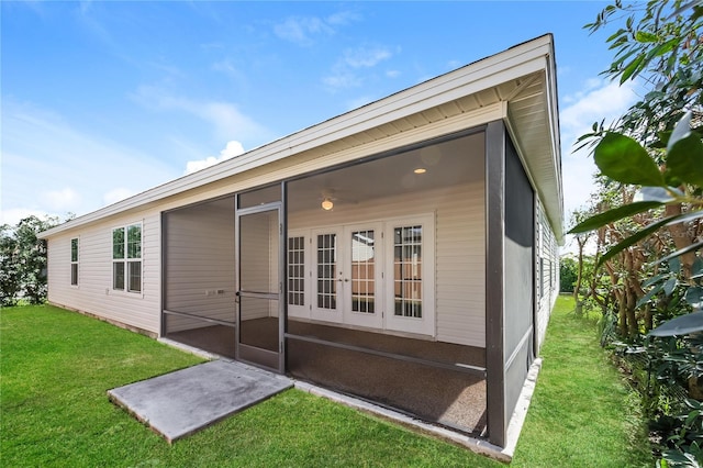 back of house featuring a yard and a sunroom