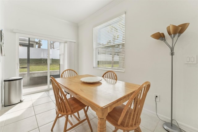 dining room featuring light tile patterned floors and crown molding