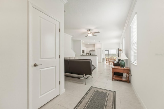 interior space with light tile patterned floors and ornamental molding