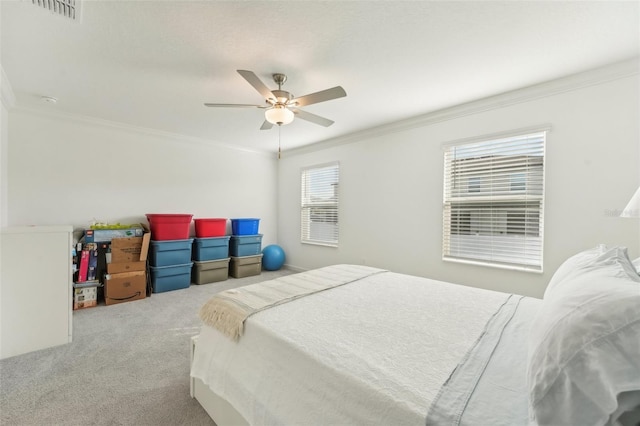 carpeted bedroom with ceiling fan and ornamental molding