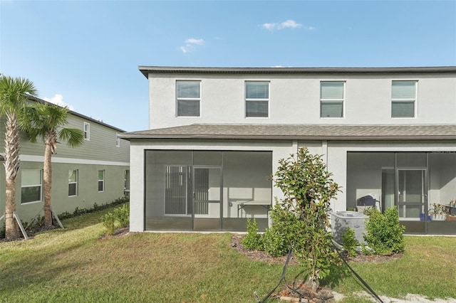 rear view of property with cooling unit, a yard, and a sunroom