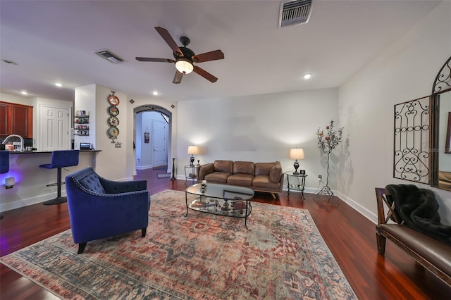 living room featuring ceiling fan and dark hardwood / wood-style flooring