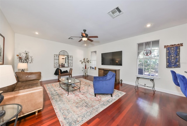 living room with dark wood-type flooring and ceiling fan