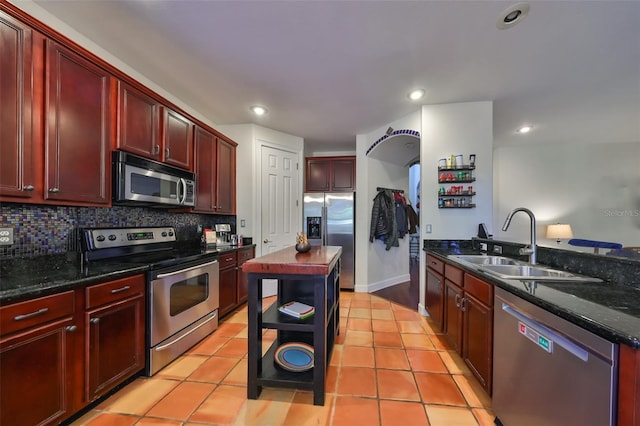 kitchen featuring tasteful backsplash, sink, a kitchen island, and appliances with stainless steel finishes