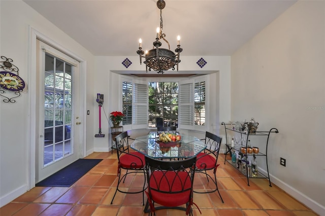 dining area with tile patterned floors and an inviting chandelier