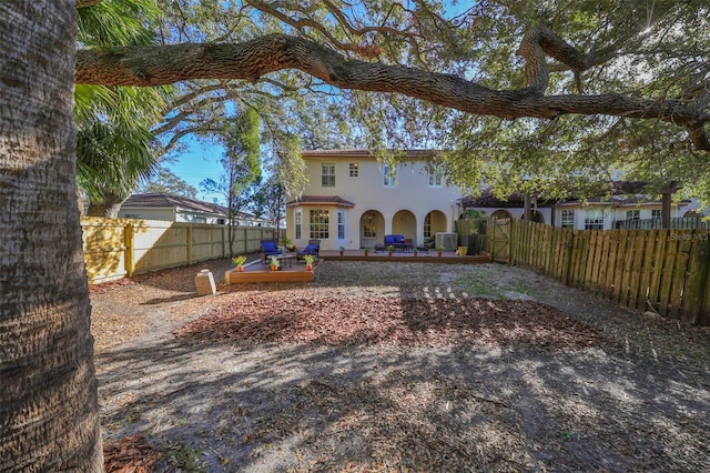 back of property with central AC and a deck