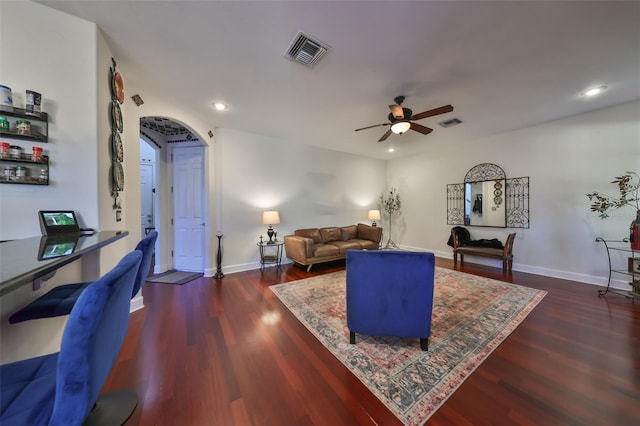 living room with ceiling fan and dark hardwood / wood-style flooring