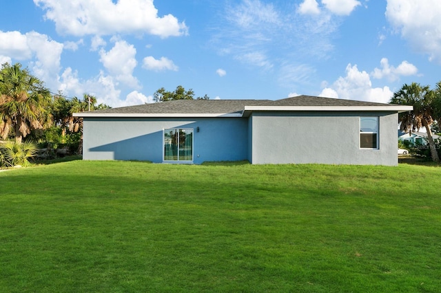 rear view of house featuring a lawn