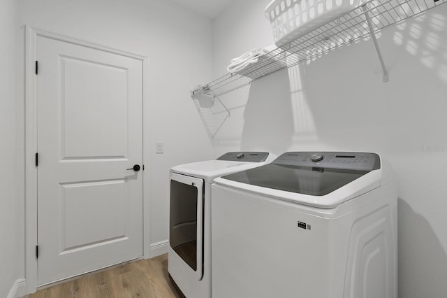 laundry area featuring washer and clothes dryer and light wood-type flooring