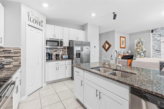 kitchen featuring dark stone countertops, sink, white cabinetry, and stainless steel appliances