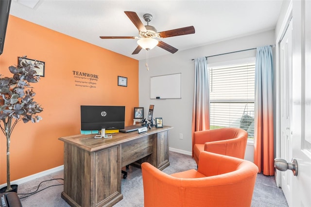 carpeted home office featuring ceiling fan