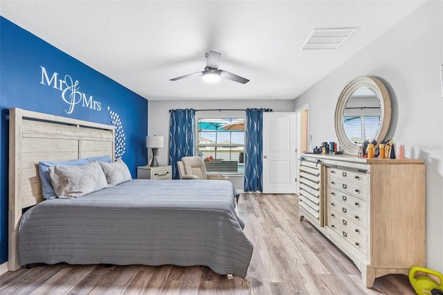 bedroom with ceiling fan, a textured ceiling, and light wood-type flooring