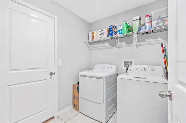 laundry area featuring washer and dryer and light tile patterned flooring