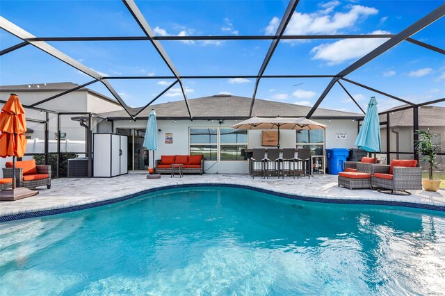 view of pool featuring a lanai, a patio area, an outdoor hangout area, and exterior bar