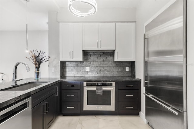 kitchen with white cabinets, decorative light fixtures, sink, and appliances with stainless steel finishes