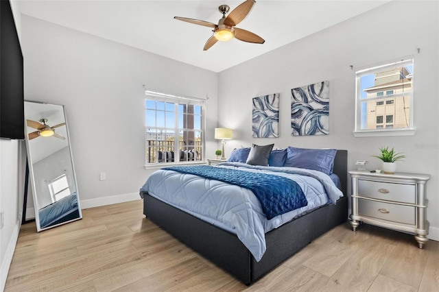 bedroom with multiple windows, light hardwood / wood-style floors, and ceiling fan