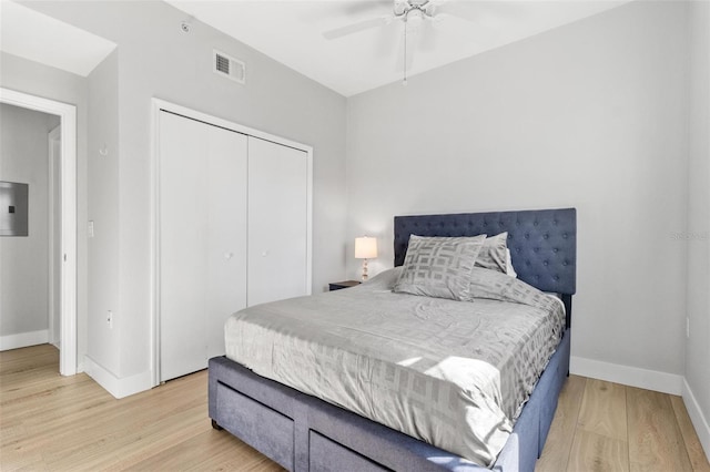 bedroom with a closet, light hardwood / wood-style flooring, and ceiling fan