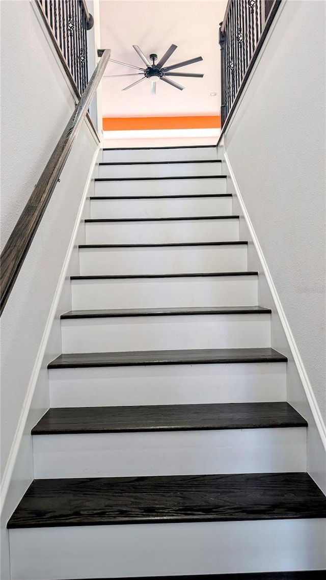 stairs featuring ceiling fan