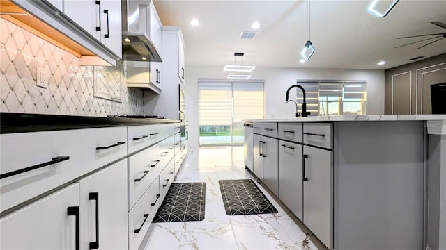 kitchen with white cabinetry, backsplash, pendant lighting, wall chimney exhaust hood, and stainless steel dishwasher