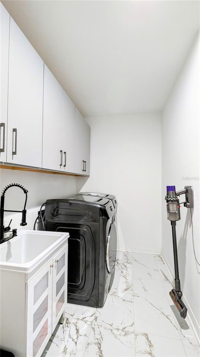 laundry area with cabinets, washer and clothes dryer, and sink