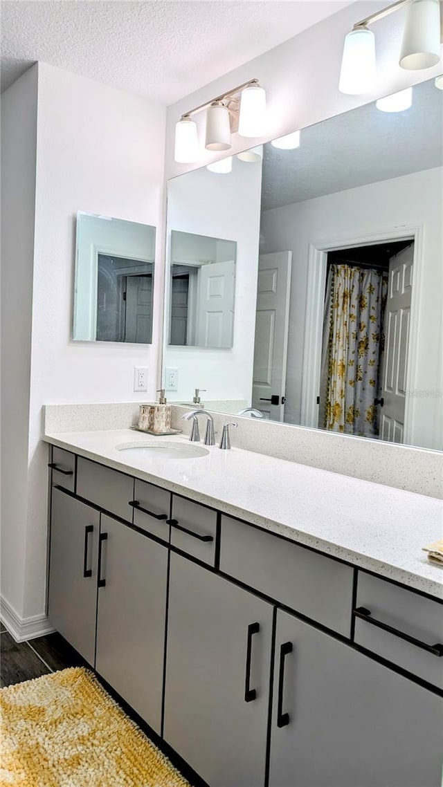 bathroom featuring a textured ceiling, wood-type flooring, and vanity