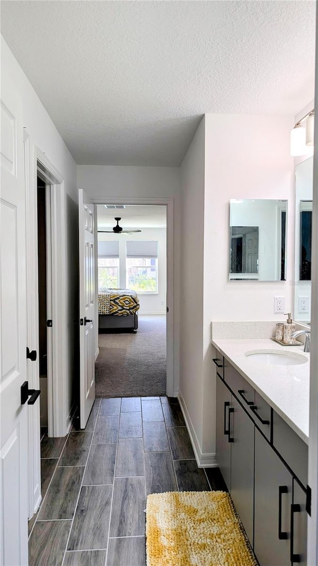 bathroom featuring ceiling fan, a textured ceiling, and vanity