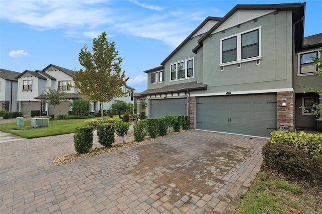 view of front of property with a front yard, a garage, and central air condition unit