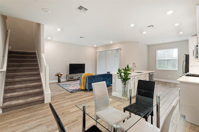 dining space featuring light wood-type flooring and sink