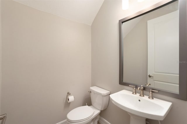 bathroom with sink, lofted ceiling, and toilet