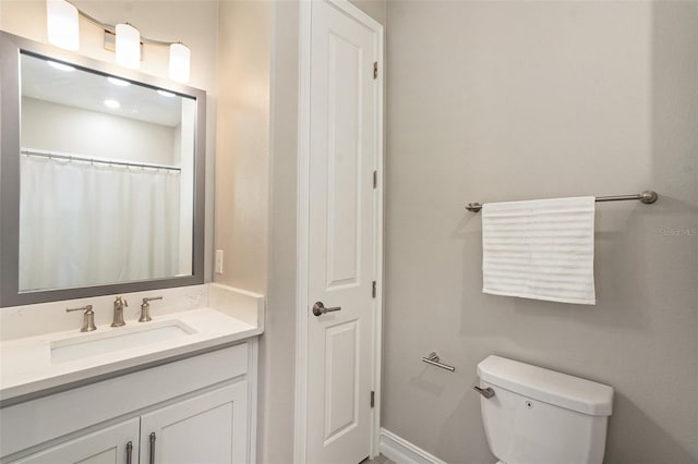 bathroom featuring a shower with shower curtain, vanity, and toilet