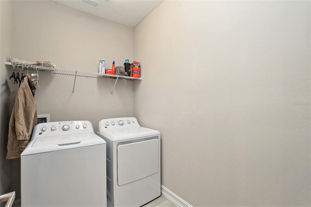 laundry room featuring separate washer and dryer and a textured ceiling