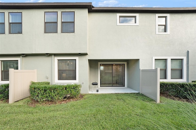 rear view of house with a lawn and a patio