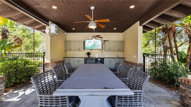 view of patio featuring exterior bar, ceiling fan, and exterior kitchen