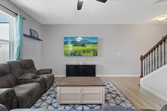 living room featuring hardwood / wood-style floors and ceiling fan