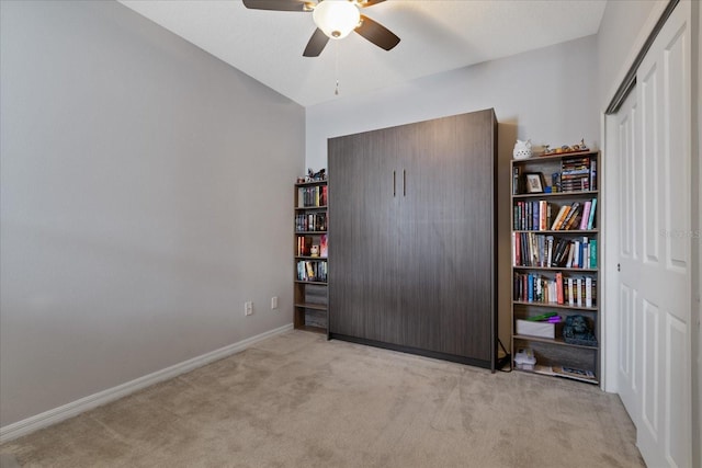 interior space featuring ceiling fan and light colored carpet