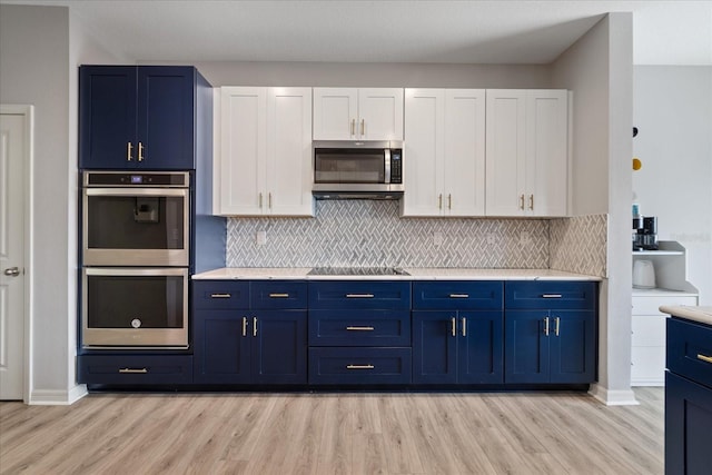 kitchen with light hardwood / wood-style flooring, white cabinets, and stainless steel appliances