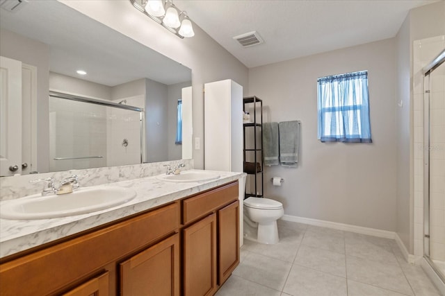 bathroom with toilet, vanity, tile patterned floors, and a shower with door