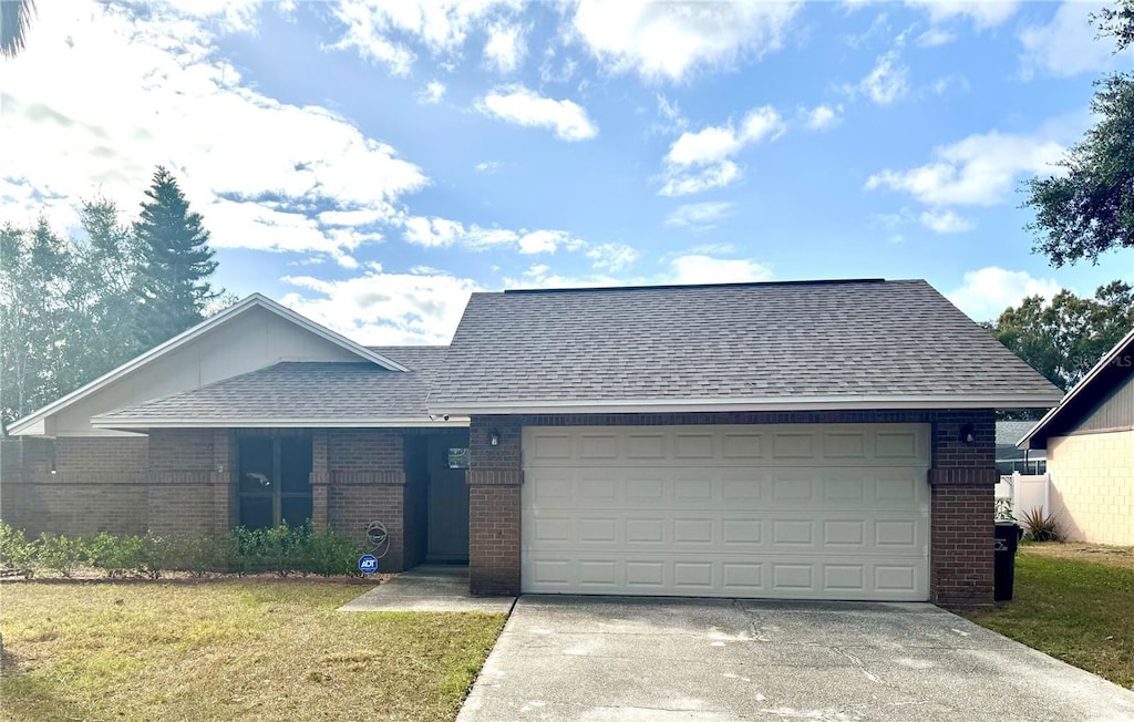 ranch-style home featuring a garage and a front lawn