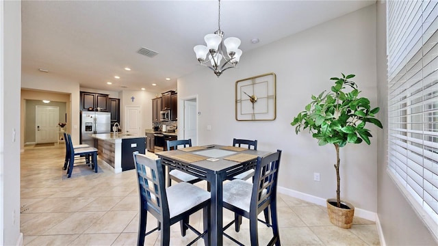 dining area with light tile patterned floors, sink, and an inviting chandelier