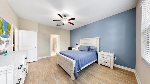 bedroom with ceiling fan, ensuite bathroom, and light hardwood / wood-style floors