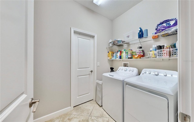 laundry area featuring a textured ceiling, separate washer and dryer, and light tile patterned flooring