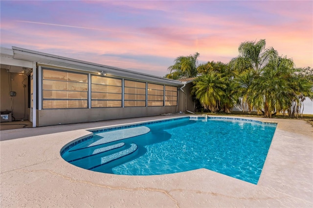 pool at dusk featuring a patio area